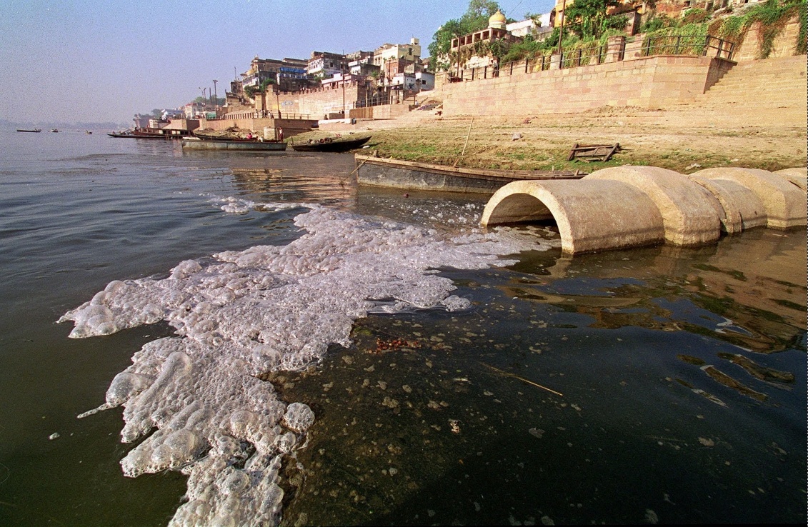 The Biggest Causes of Water Pollution in India – Telegraph
A large concrete drainage pipe releasing foamy, untreated wastewater into the Ganges River near the ghats, with boats and historic architecture in the background.
